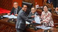 Jakarta, Nusantara Info: Dewan Perwakilan Rakyat (DPR) resmi mengesahkan Revisi Kitab Undang-Undang Hukum Acara Pidana (KUHAP) menjadi undang-undang dalam Rapat Paripurna yang digelar di Kompleks Parlemen, Senayan, Jakarta Pusat, Selasa (18/11/2025). Pengesahan ini dilakukan setelah melalui pembahasan panjang antara Komisi III DPR dan pemerintah. KUHAP baru akan mulai berlaku efektif pada 2 Januari 2026, beriringan dengan penerapan Kitab Undang-Undang Hukum Pidana (KUHP) yang telah disahkan sebelumnya. Rapat paripurna dipimpin oleh Ketua DPR Puan Maharani dan didampingi para Wakil Ketua DPR, yakni Sufmi Dasco Ahmad, Cucun Ahmad Syamsurijal, Adies Kadir, dan Saan Mustopa. Hadir pula Menteri Hukum dan HAM (Menkumham) Supratman Andi Agtas, Wakil Menteri Sekretaris Negara Bambang Eko Suhariyanto, serta Wakil Menteri Hukum dan HAM Edward Omar Sharif Hiariej. Sebanyak 242 anggota DPR tercatat hadir dalam rapat tersebut. Pada awal rapat, Puan mempersilakan Ketua Komisi III DPR, Habiburokhman, menyampaikan laporan hasil pembahasan revisi KUHAP. Komisi III dan pemerintah sebelumnya telah menyepakati pembahasan RKUHAP naik ke tingkat II pada Kamis (13/11/2025). Selanjutnya, Puan meminta persetujuan seluruh anggota Dewan untuk pengesahan revisi KUHAP. Secara bulat, seluruh fraksi menyatakan setuju. “Apakah dapat disetujui untuk disahkan menjadi undang-undang?” tanya Puan. “Setuju,” jawab para anggota Dewan serentak, sebelum palu persetujuan diketuk. Berlaku Serentak dengan KUHP pada 2 Januari 2026 Menkumham Supratman Andi Agtas menegaskan bahwa KUHAP baru akan berlaku pada 2 Januari 2026, bersamaan dengan berlakunya KUHP yang telah ditetapkan sebagai UU Nomor 1 Tahun 2023. “Dengan berlakunya KUHP kita di tahun 2026, 2 Januari yang akan datang, sekarang KUHAP-nya juga sudah siap. Jadi otomatis dua hal ini, hukum materiil dan formilnya, dua-duanya sudah siap,” ujarnya. Supratman juga menyoroti masa transisi yang dinilai sudah cukup untuk mempersiapkan implementasi KUHAP di berbagai institusi penegak hukum. Partisipasi Publik Disebut Paling Luas Pemerintah mengeklaim penyusunan KUHAP baru ini melibatkan partisipasi publik secara luas. Menurut Supratman, pembahasan dilakukan dengan mengundang fakultas hukum dari seluruh perguruan tinggi di Indonesia melalui berbagai forum, termasuk diskusi virtual. “Belum pernah ada undang-undang yang dilakukan meaningful participation seperti halnya dengan KUHAP,” ujarnya. Ketua DPR Puan Maharani juga menegaskan bahwa revisi KUHAP telah menerima lebih dari 130 masukan publik dalam proses pembahasannya sejak 2023 dan menjelajahi berbagai daerah untuk menjaring aspirasi. Ada Penolakan, Pemerintah Sebut Hal Wajar Meski demikian, Supratman tak menampik masih adanya penolakan dari sejumlah pihak terhadap KUHAP baru. Namun menurutnya, kritik tersebut wajar dalam proses pembentukan undang-undang. Ia menekankan bahwa KUHAP hasil revisi ini memuat sejumlah prinsip penting, antara lain: • Penguatan perlindungan hak asasi manusia (HAM) • Penerapan restorative justice • Perluasan objek praperadilan untuk mengurangi potensi kesewenang-wenangan • Perlindungan khusus bagi penyandang disabilitas “Ada yang setuju, ada yang tidak. Itu biasa. Tapi KUHAP kali ini sangat memprioritaskan HAM, restorative justice, dan perluasan praperadilan,” ucap Supratman. Banyak Aturan Diperbarui Ketua DPR Puan Maharani kembali menegaskan bahwa KUHAP baru akan resmi berlaku pada 2 Januari 2026. “Undang-undang ini akan mulai berlaku nanti tanggal 2 Januari 2026,” ujarnya. Puan juga mengatakan revisi KUHAP membawa banyak pembaruan penting untuk memperkuat sistem peradilan pidana nasional. (*)